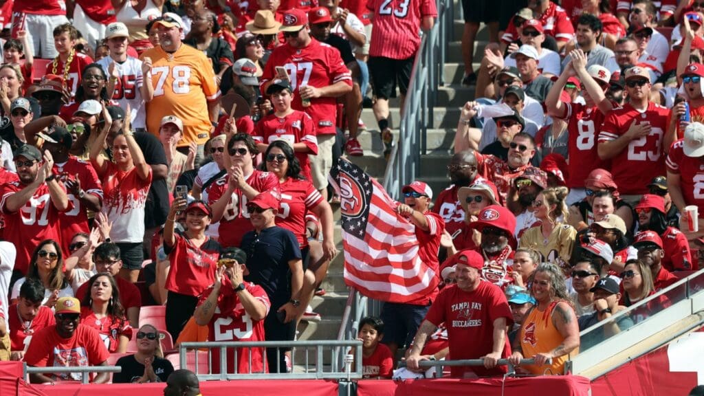 Nov 10, 2024; Tampa, Florida, USA; San Francisco 49ers fans cheer and hold up an American flag against the Tampa Bay Buccaneers during the first half at Raymond James Stadium.