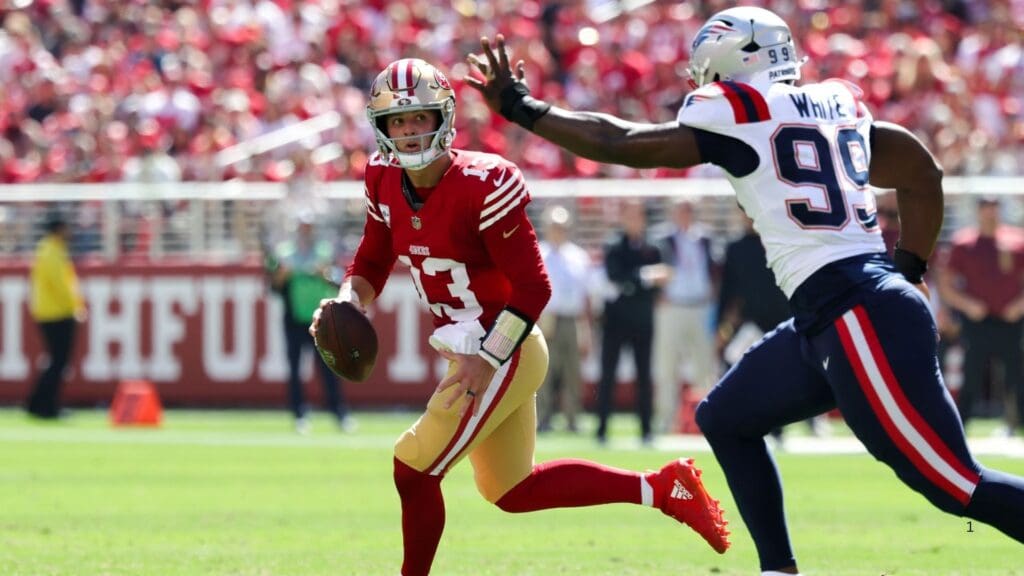 Sep 29, 2024; Santa Clara, California, USA; San Francisco 49ers quarterback Brock Purdy (13) runs away from New England Patriots defensive end Keion White (99) during the first quarter at Levi's Stadium.