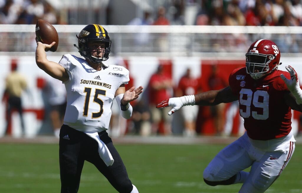 In this 2019 photo, Southern Miss Golden Eagles quarterback Jack Abraham (15) throws a pass as Alabama Crimson Tide defensive lineman Raekwon Davis (99) pursues during the first half.