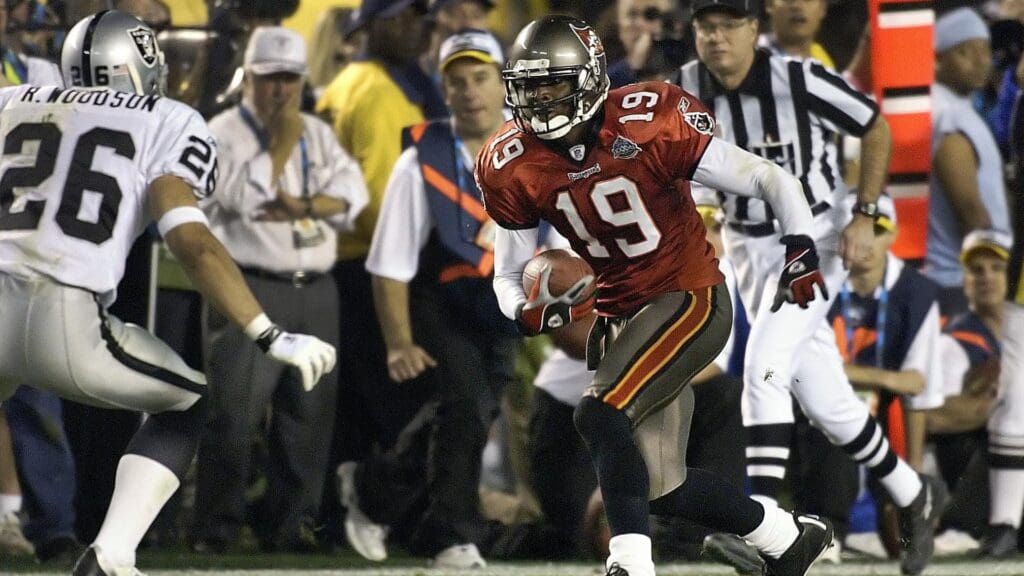 Jan 26, 2003; San Diego, CA, USA; FILE PHOTO; Tamp Bay Buccaneers receiver Keyshawn Johnson (19) carries the ball as Oakland Raiders defensive back Rod Woodson (26) closes in during Super Bowl XXXVII at Qualcomm Stadium. The Bucs defeated the Raiders 48-21.