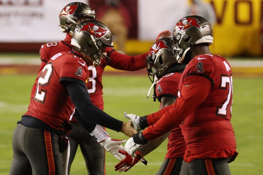 Jan 9, 2021; Landover, Maryland, USA; Tampa Bay Buccaneers quarterback Tom Brady (12) celebrates with teammates in the final two minutes against the Washington Football Team in the fourth quarter at FedExField