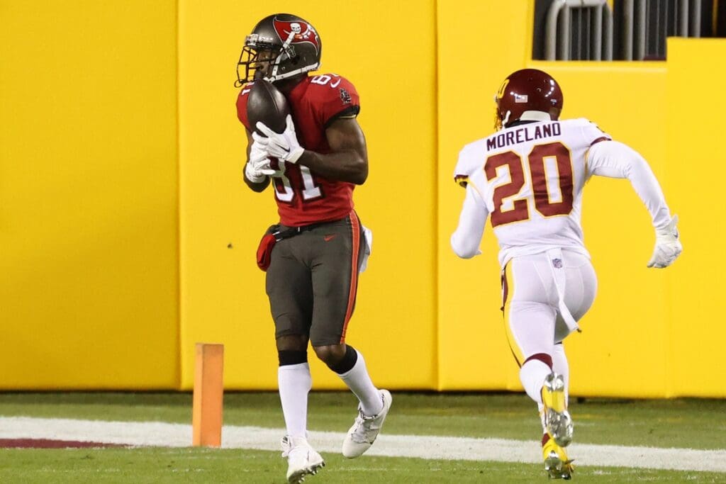 Jan 9, 2021; Landover, Maryland, USA; Tampa Bay Buccaneers wide receiver Antonio Brown (81) catches a touchdown pass as Washington Football Team cornerback Jimmy Moreland (20) chases in the second quarter at FedExField.