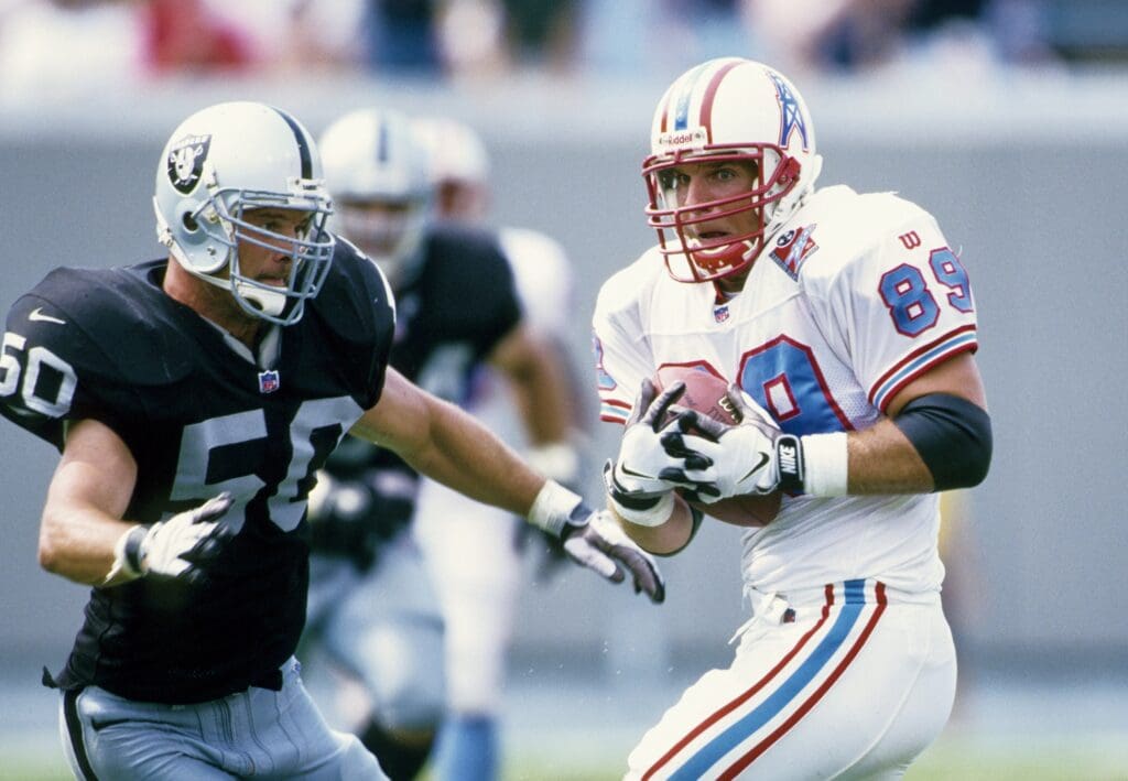 Aug 31, 1997; Memphis, TN, USA; FILE PHOTO; Tennessee Oilers tight end Frank Wycheck (89) catches a pass under pressure from Oakland Raiders linebacker Mike Morton (50) at Liberty Bowl Memorial Stadium.