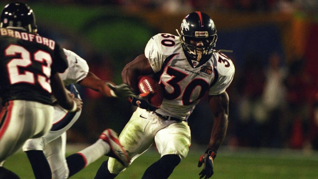 Jan 31, 1999; Miami, FL, USA; FILE PHOTO; Denver Broncos running back Terrell Davis (30) carries the ball against Atlanta Falcons cornerback Ronnie Bradford (23) during Super Bowl XXXIII at Dolphin Stadium. The Broncos defeated the Falcons 34-19.