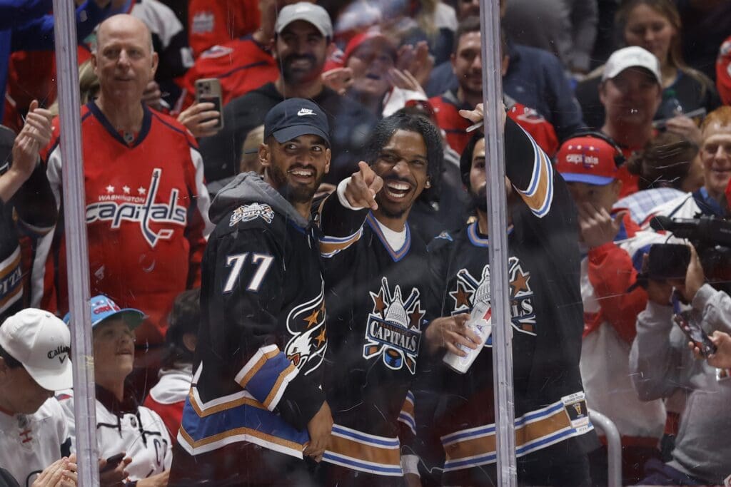 Apr 23, 2025; Washington, District of Columbia, USA; Washington Commanders quarterback Jayden Daniels (M) gestures from the glass during a stoppage in play in the game between the Washington Capitals and Montreal Canadiens in the first period in game two of the first round of the 2025 Stanley Cup Playoffs at Capital One Arena.