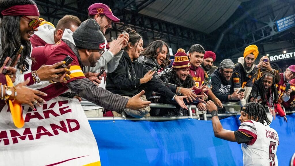 Washington Commanders quarterback Jayden Daniels shakes hands and high-fives fans after defeating the Detroit Lions 45-31 in the NFC divisional round playoff game at Ford Field in Detroit, Saturday, Jan. 18, 2025.
