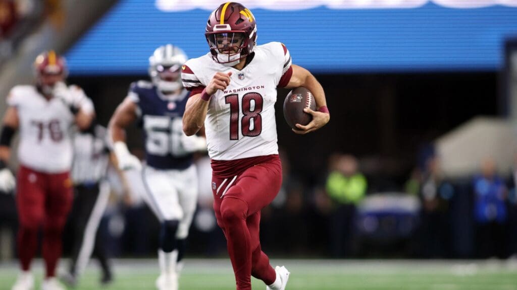 Jan 5, 2025; Arlington, Texas, USA; Washington Commanders quarterback Marcus Mariota (18) runs for a first down against the Dallas Cowboys during the fourth quarter at AT&T Stadium.