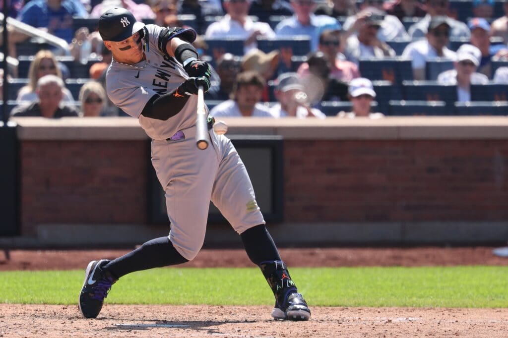 Jul 6, 2025; New York City, New York, USA; New York Yankees right fielder Aaron Judge (99) hits an RBI sacrifice fly to left field during the seventh inning against the New York Mets at Citi Field.
