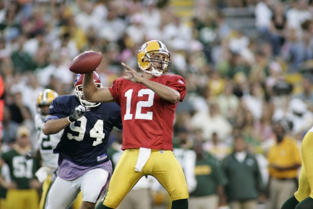 August 5, 2005; Green Bay, WI, USA; Aaron Rodgers #12 of the Green Bay Packers passes as Aaron Schobel #94 of the Buffalo Bills rushes from behind at Lambeau Field