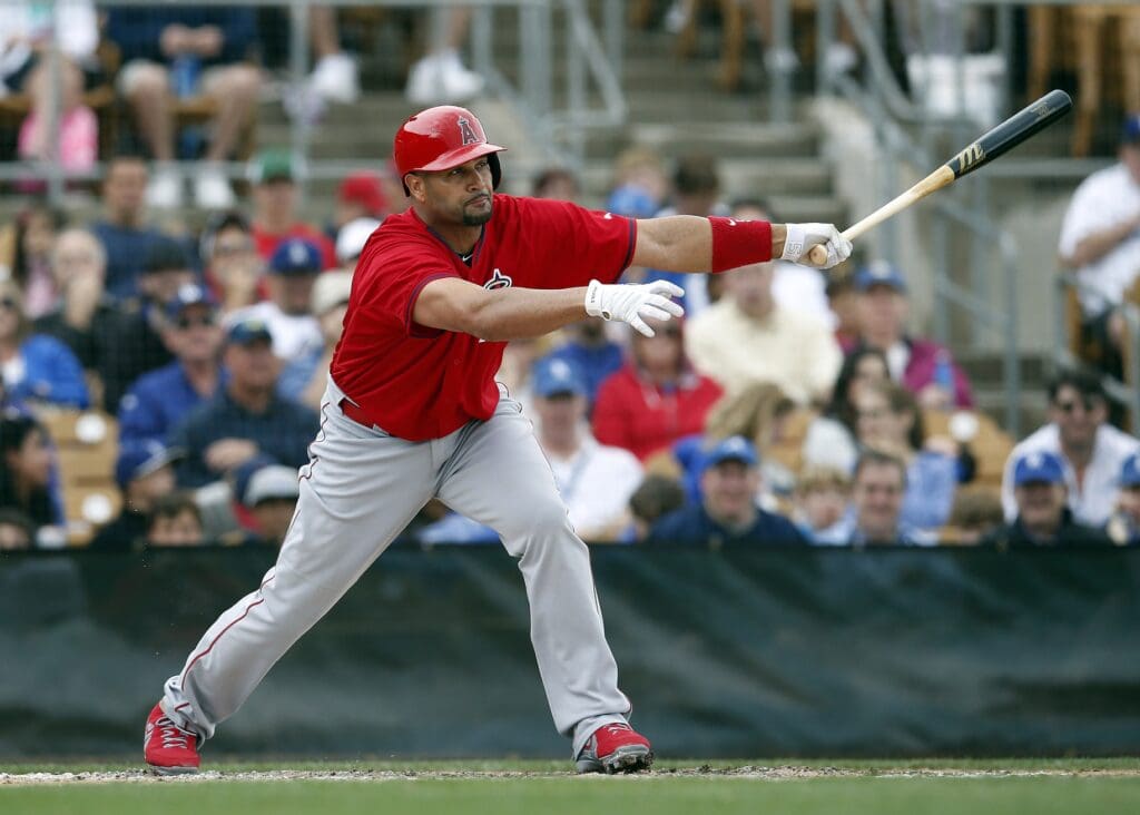 Mar 19, 2015; Phoenix, AZ, USA; Los Angeles Angels first baseman Albert Pujols (5) hits an RBI single in the second inning against the Los Angeles Dodgers during a spring training game at Camelback Ranch.