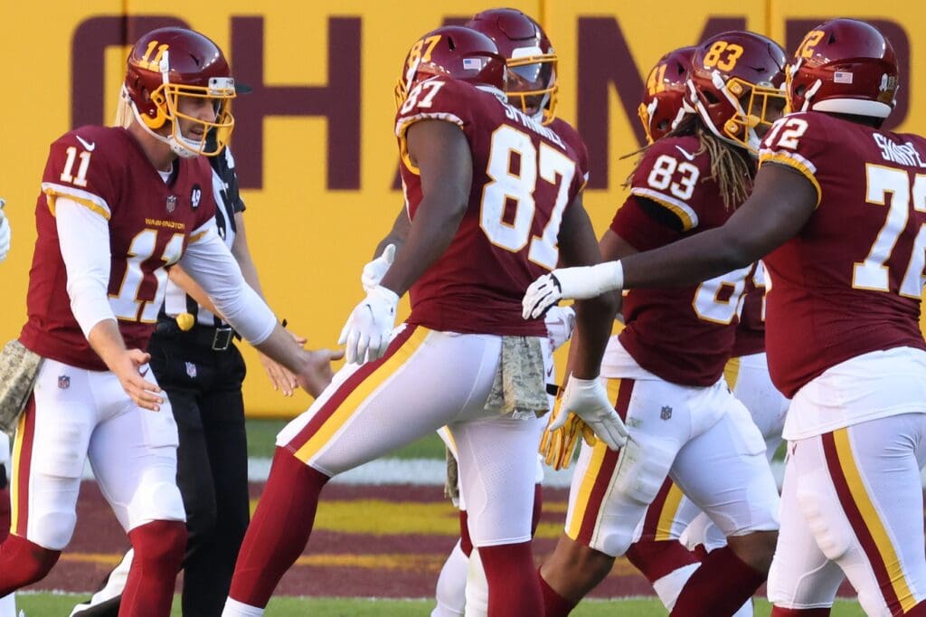 Nov 8, 2020; Landover, Maryland, USA; Washington Football Team quarterback Alex Smith (11) celebrates with teammates after a touchdown by Washington Football Team running back Antonio Gibson (not pictured) against the New York Giants in the third quarter at FedExField.