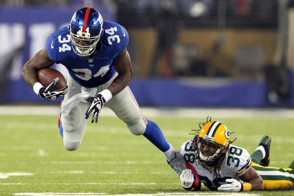 Nov 17, 2013; East Rutherford, NJ, USA; New York Giants running back Brandon Jacobs (34) is tackled by Green Bay Packers corner back Tramon Williams (38) during the first quarter of a game at MetLife Stadium. 