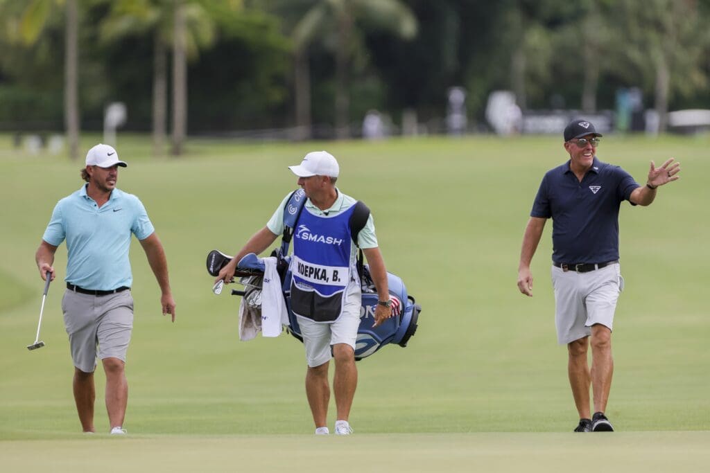 Oct 20, 2023; Doral, Florida, USA; Brooks Koepka, left, and Phil Mickelson walk on the seventh hole fairway during the first round of the LIV Golf Miami golf tournament at Trump National Doral.