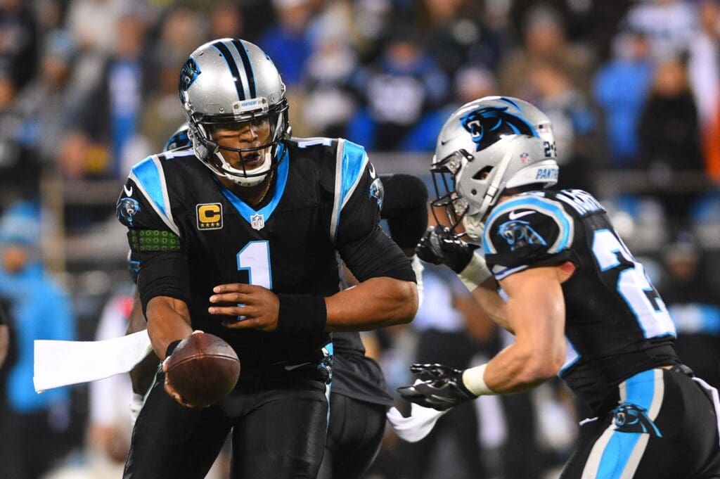 Dec 17, 2018; Charlotte, NC, USA; Carolina Panthers quarterback Cam Newton (1) hands the ball off to running back Christian McCaffrey (22) in the first quarter at Bank of America Stadium.
