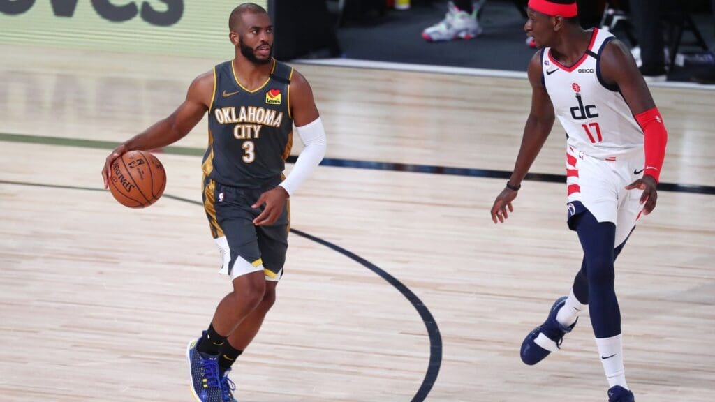 Aug 9, 2020; Lake Buena Vista, Florida, USA; Oklahoma City Thunder guard Chris Paul (3) brings the ball up court against Washington Wizards forward Isaac Bonga (17) during the second half of a NBA basketball game at AdventHealth Arena.