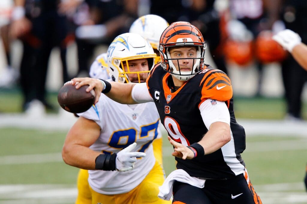 Sep 13, 2020; Cincinnati, Ohio, USA; Cincinnati Bengals quarterback Joe Burrow (9) throws on the run as Los Angeles Chargers defensive end Joey Bosa (97) pursues on the play during the fourth quarter at Paul Brown Stadium.