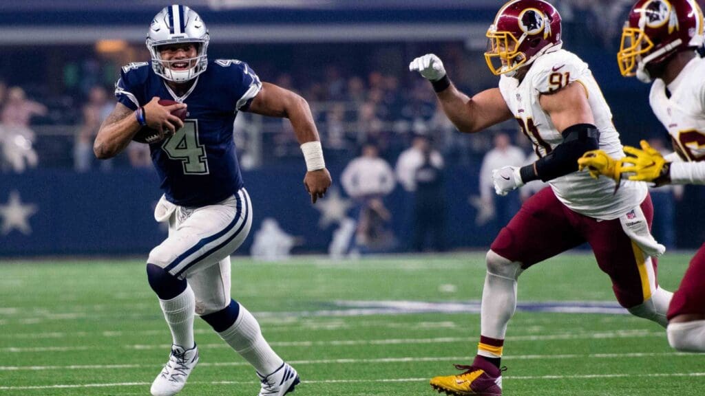 Nov 24, 2016; Arlington, TX, USA; Dallas Cowboys quarterback Dak Prescott (4) eludes Washington Redskins outside linebacker Ryan Kerrigan (91) during the game at AT&T Stadium. The Cowboys defeat the Redskins 31-26.