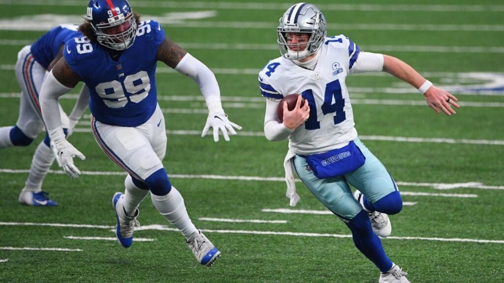 Jan 3, 2021; East Rutherford, NJ, USA; Dallas Cowboys quarterback Andy Dalton (14) runs from New York Giants defensive end Leonard Williams (99) in the second half at MetLife Stadium.