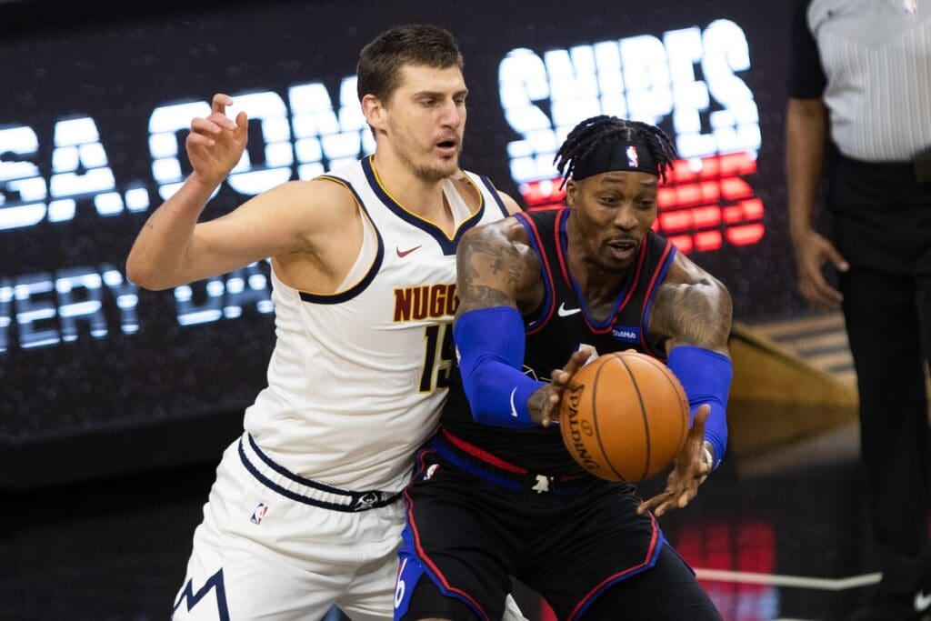Jan 9, 2021; Philadelphia, Pennsylvania, USA; Philadelphia 76ers center Dwight Howard (39) receives a pass in front of Denver Nuggets center Nikola Jokic (15) during the first quarter at Wells Fargo Center. 