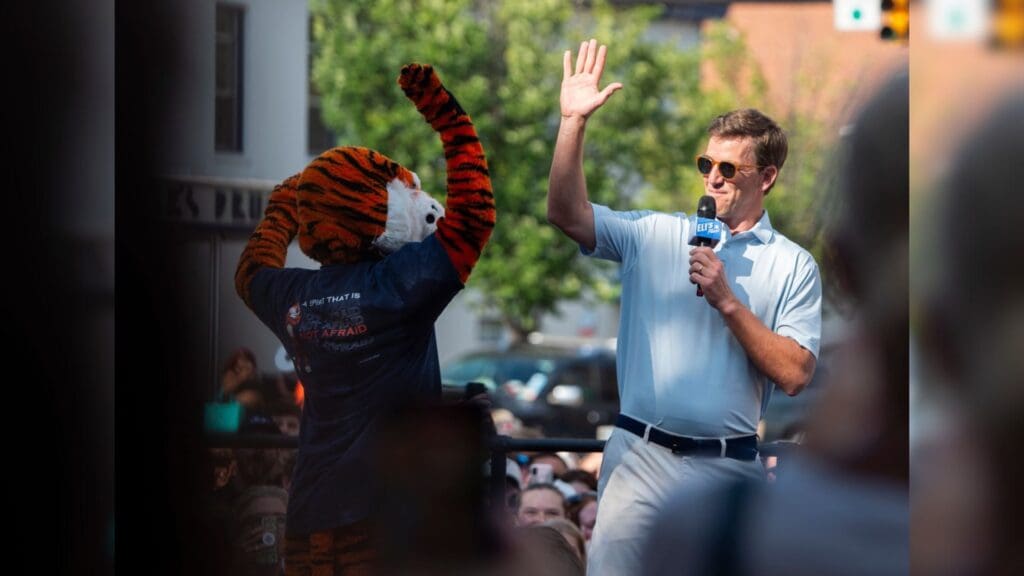 Eli Manning greets Aubie during the filming of the ESPN show Eli’s Places at Toomer’s Corner in Auburn, Ala. on Tuesday, July 8, 2025.