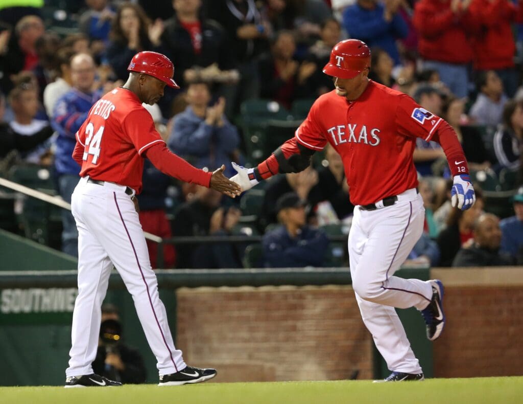 Apr 20, 2013; Arlington, TX, USA; Texas Rangers catcher A.J. Pierzynski (12) is congratulated by Texas Rangers third base coach Gary Pettis (24) after his home run against the Seattle Mariners during the fourth inning at Rangers Ballpark in Arlington.