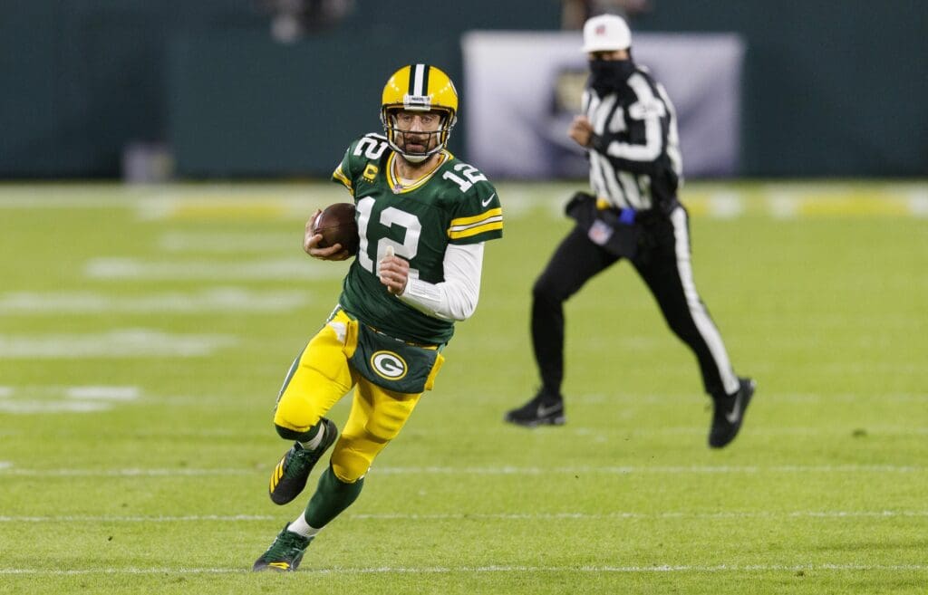 Nov 29, 2020; Green Bay, Wisconsin, USA; Green Bay Packers quarterback Aaron Rodgers (12) rushes with the football during the first quarter against the Chicago Bears at Lambeau Field.