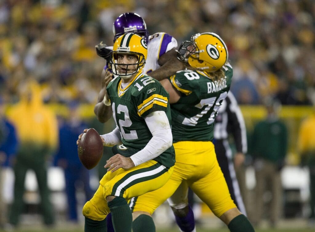 Nov 1, 2009; Green Bay, WI, USA; Green Bay Packers quarterback Aaron Rodgers (12) looks for a receiver as guard Allen Barbre (78) blocks Minnesota Vikings defensive end Ray Edwards (91) during the third quarter at Lambeau Field. The Vikings defeated the Packers 38-26. 