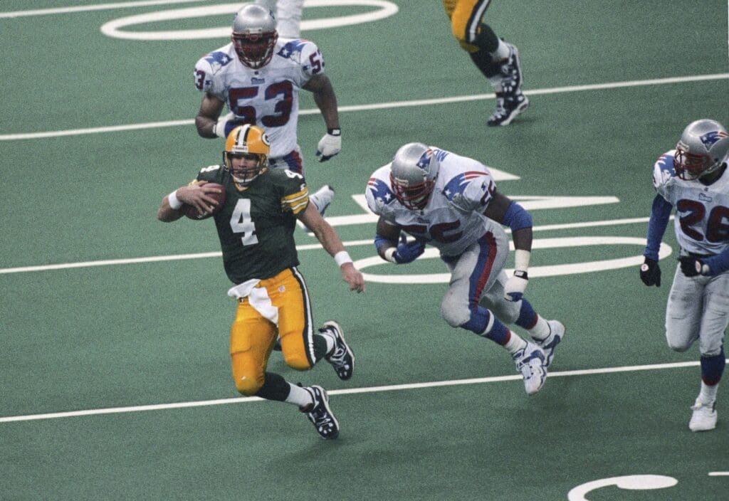 Jan 26, 1997; New Orleans, LA, USA; FILE PHOTO; Green Bay Packers quarterback Brett Favre (4) in action against New England Patriots defensive end Willie McGinest (55) and linebacker Chris Slade (53) during Super Bowl XXXI at the Superdome. Green Bay defeated New England 35-21.