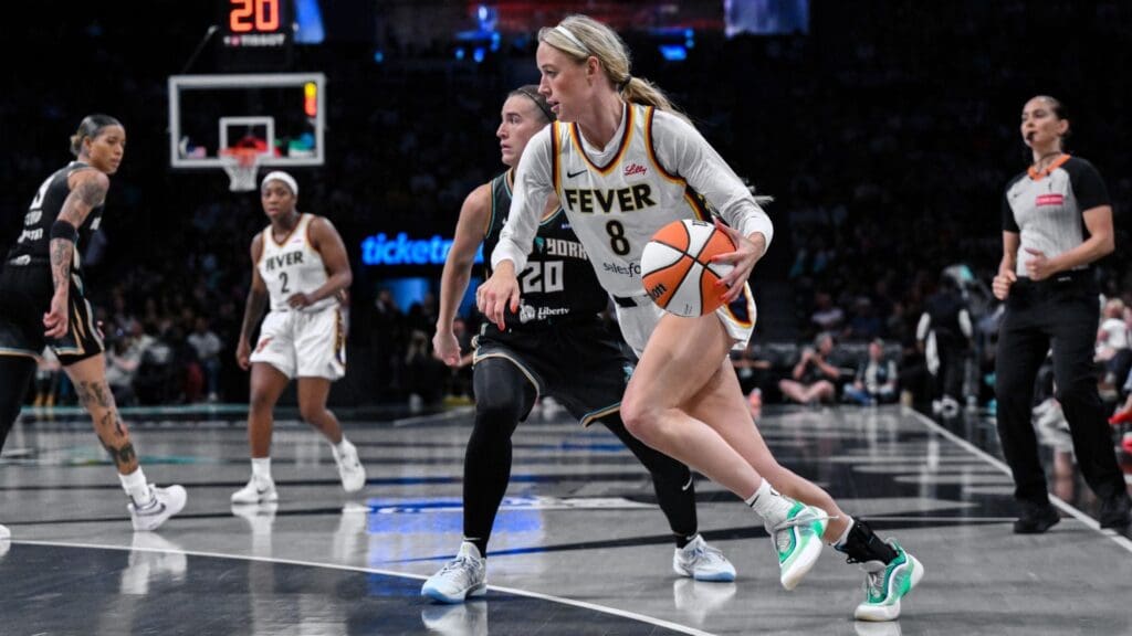 Jul 16, 2025; Brooklyn, New York, USA; Indiana Fever guard Sophie Cunningham (8) drives past New York Liberty guard Sabrina Ionescu (20) during the second half at Barclays Center.