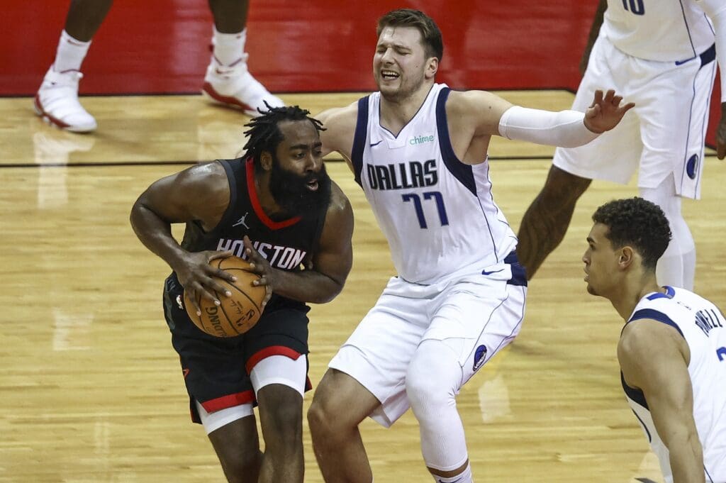Jan 4, 2021; Houston, Texas, USA; Houston Rockets guard James Harden (13) controls the ball as Dallas Mavericks guard Luka Doncic (77) defends during the third quarter at Toyota Center.