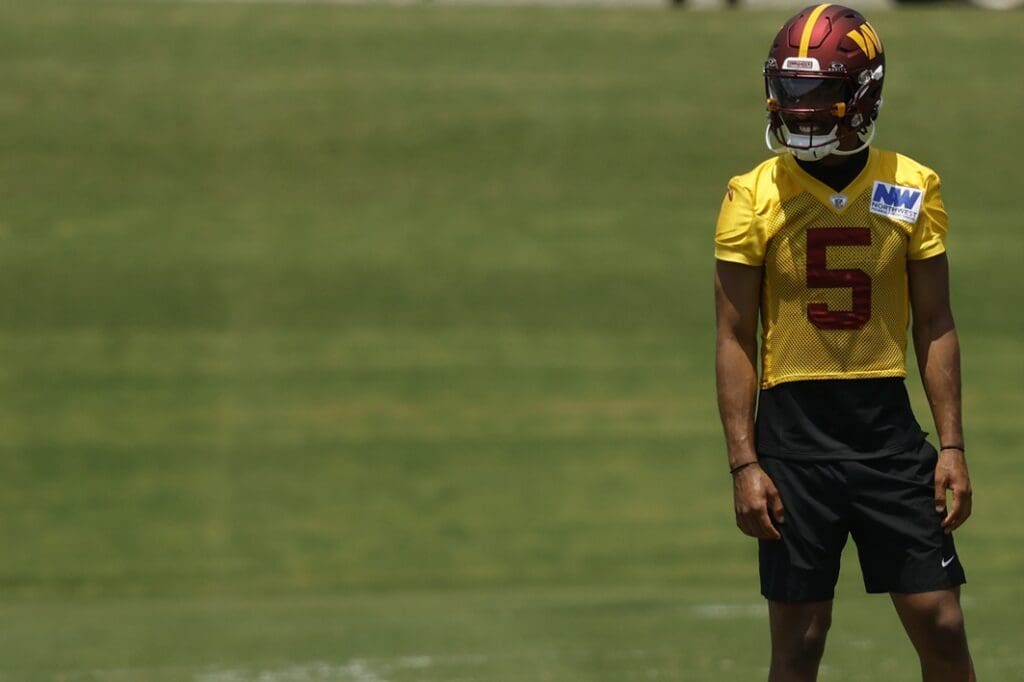 Jun 10, 2025; Ashburn, VA, USA; Washington Commanders quarterback Jayden Daniels (5) stands on the field between drills on day one of minicamp at Commanders Park