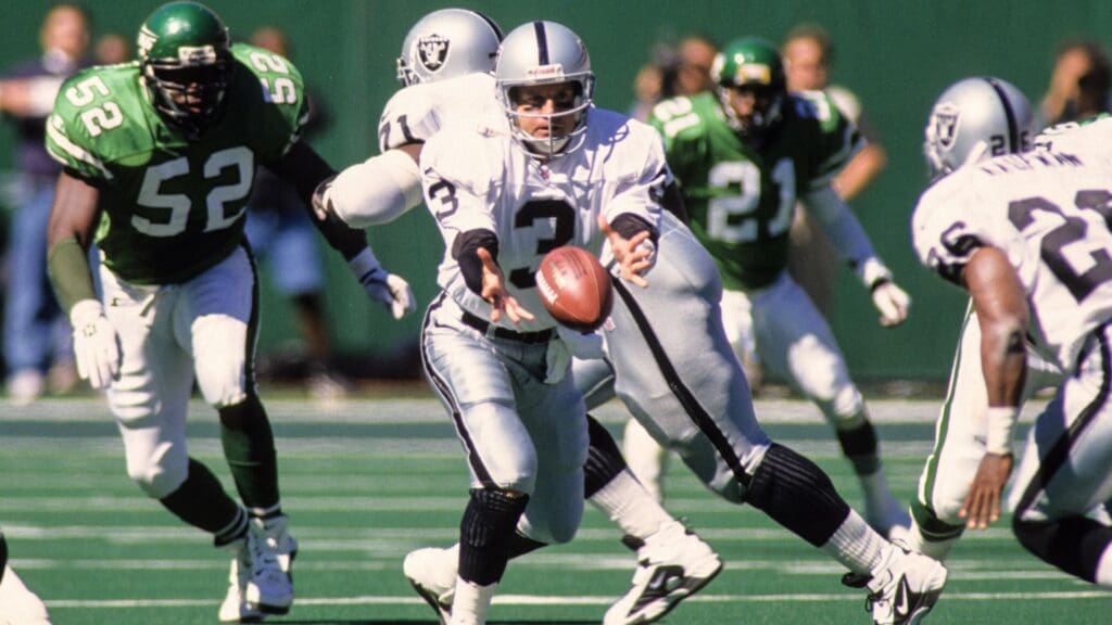 Sep 21, 1997; East Rutherford, NJ, USA; FILE PHOTO; Oakland Raiders quarterback Jeff George (3) pitches the ball to Napoleon Kaufman (26) against New York Jets linebacker Pepper Johnson (52) at Giants Stadium.