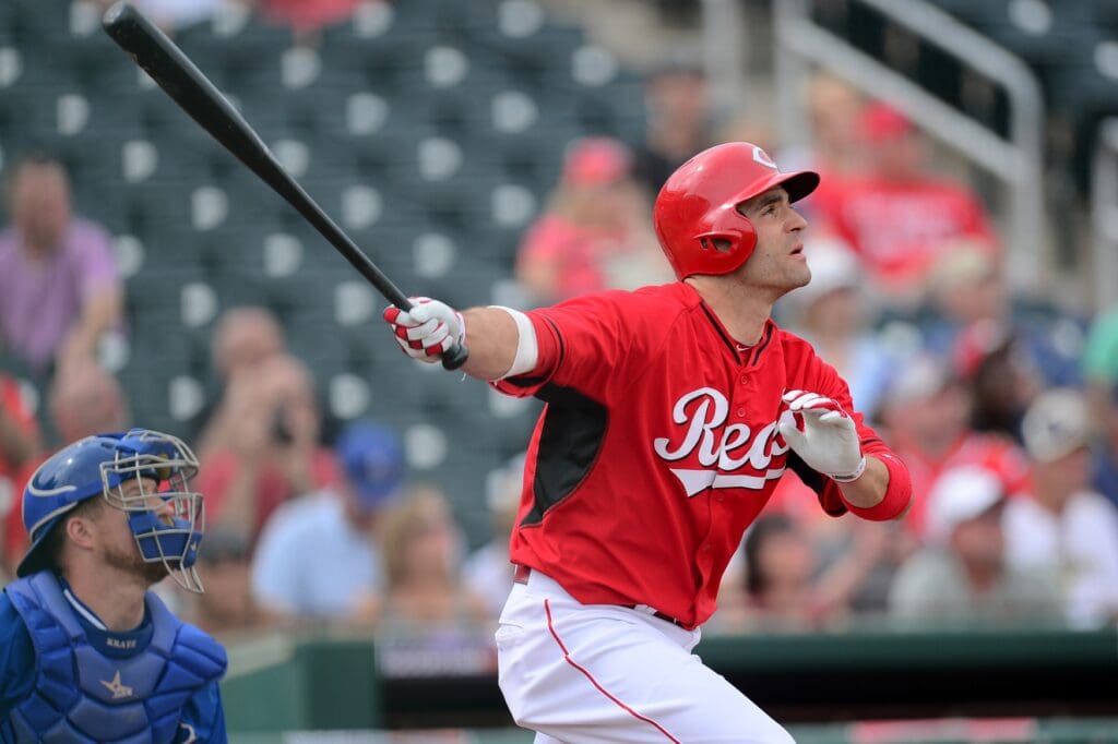 Mar 11, 2015; Goodyear, AZ, USA; Cincinnati Reds first baseman Joey Votto (19) hits a sacrifice fly RBI against the Kansas City Royals at Goodyear Ballpark.