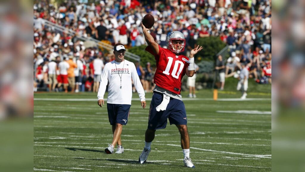 Jul 28, 2016; Foxboro, MA, USA; New England Patriots quarterback Jimmy Garoppolo (10) throws as offensive coordinator Josh McDaniels looks on during training camp at Gillette Stadium.