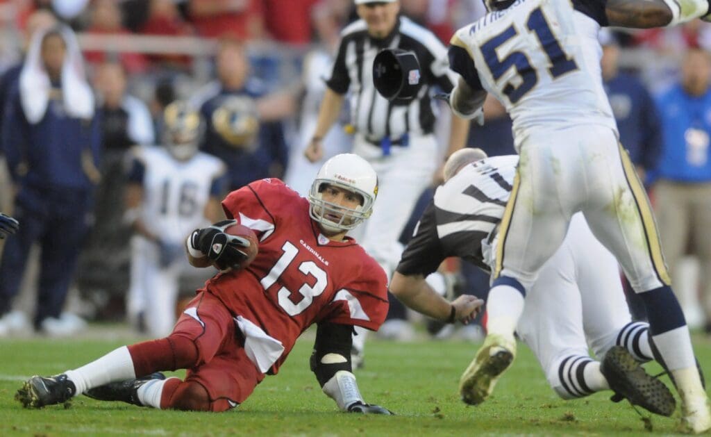 Dec. 30, 2007; Glendale, AZ, USA; Arizona Cardinals quarterback Kurt Warner (13) slides to the ground as a referee is hit against the St Louis Rams at University of Phoenix Stadium. Arizona defeated St Louis 48-19.