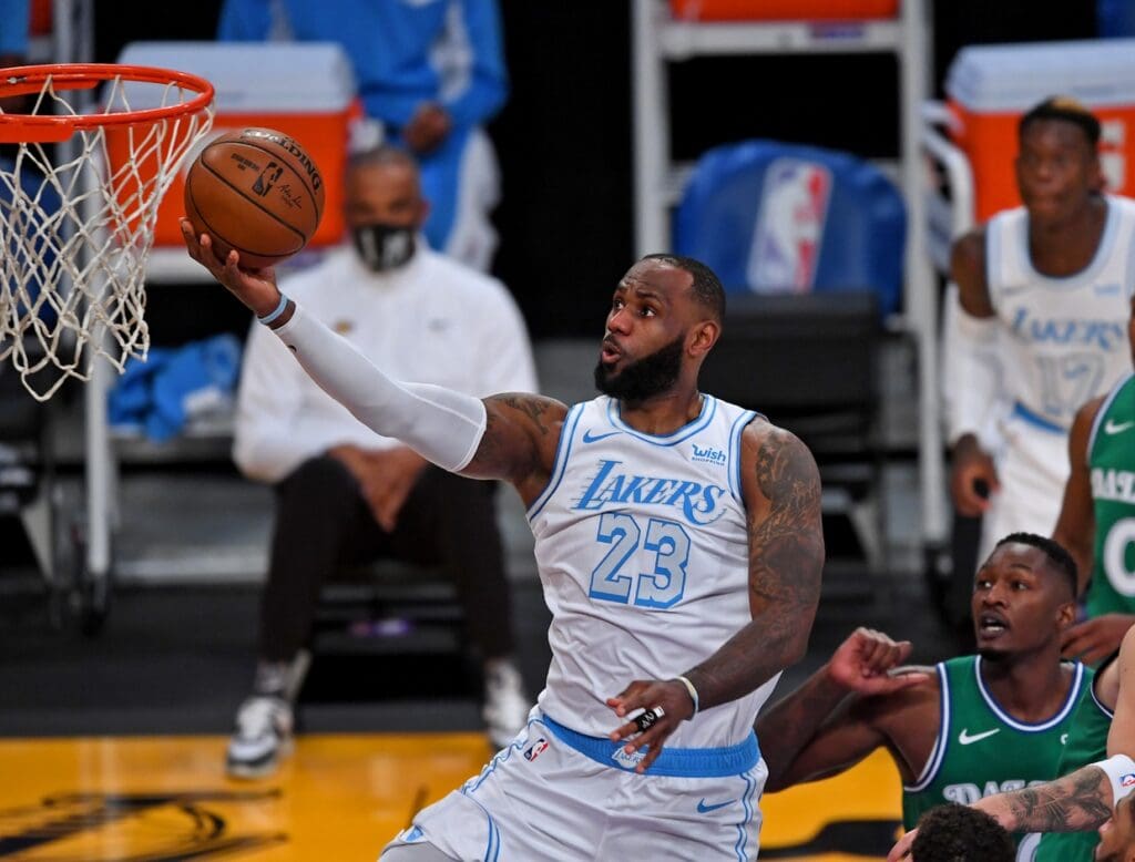 Dec 25, 2020; Los Angeles, California, USA; Los Angeles Lakers forward LeBron James (23) drives past Dallas Mavericks forward Dorian Finney-Smith (10) and Dallas Mavericks guard Luka Doncic (77) for a basket in the first quarter of the game at Staples Center. 