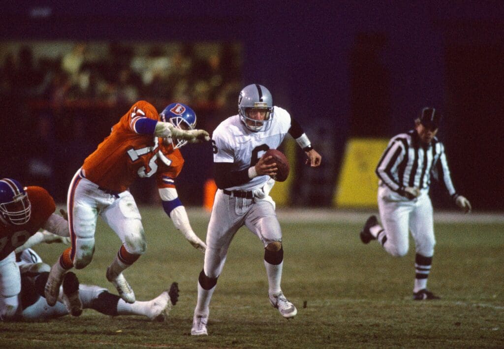 Unknown Date, 1985; Unknown Location, USA; FILE PHOTO; Los Angeles Raiders quarterback Marc Wilson (6) in action against Denver Broncos defensive end Rulon Jones (75) during the 1985 season. 