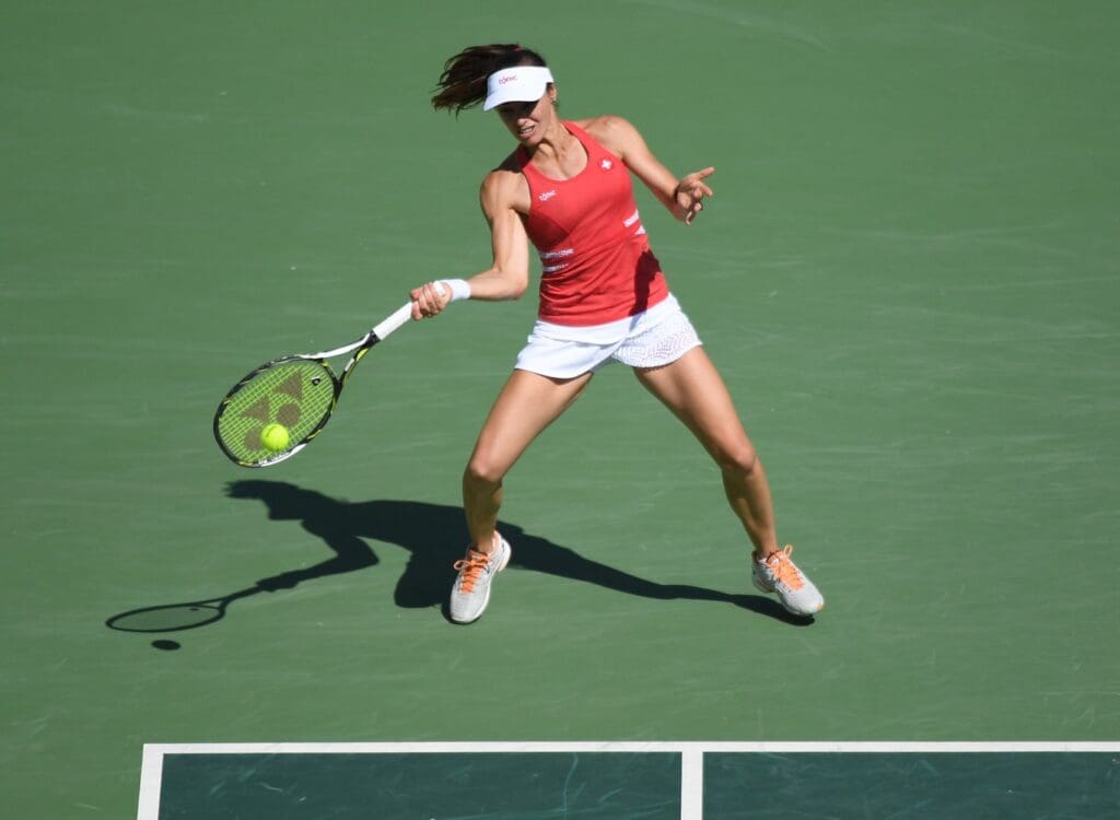 Aug 14, 2016; Rio de Janeiro, Brazil; Martina Hingis (SUI) returns a serve as she and Timea Bacsinszky (SUI) compete in a women s doubles gold medal match against Ekaterina Makarova (RUS) and Elena Vesnina (RUS) at Olympic Tennis Centre during the Rio 2016 Summer Olympic Games.