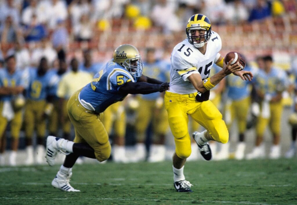 Sep 26, 1989; Pasadena, CA, USA: FILE PHOTO; Michigan Wolverines quarterback Elvis Grbac (15) in action against UCLA Bruins linebacker Stacey Elliott (52) at the Rose Bowl.