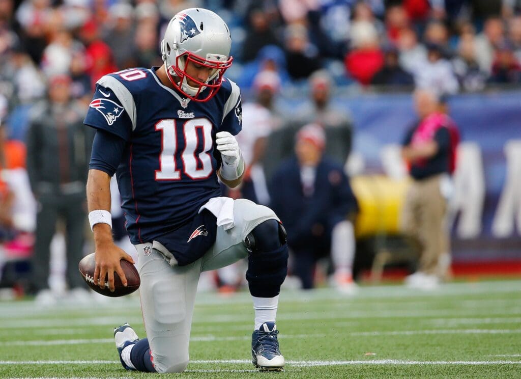 Oct 26, 2014; Foxborough, MA, USA; New England Patriots quarterback Jimmy Garoppolo (10) kneels on the ground after being sacked during the second half of New England's 51-23 win over the Chicago Bears at Gillette Stadium. 