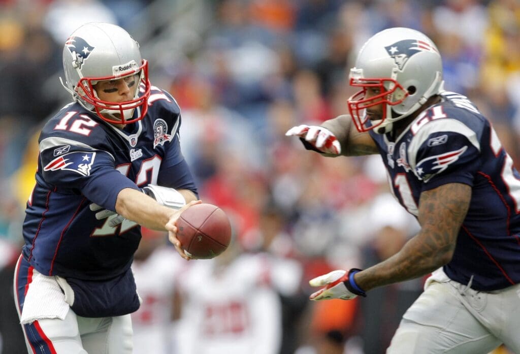 Sep 27, 2009; Foxborough, MA, USA; New England Patriots quarterback Tom Brady (12) hands off the ball to running back Fred Taylor (21) against the Atlanta Falcons during the first period at Gillette Stadium.