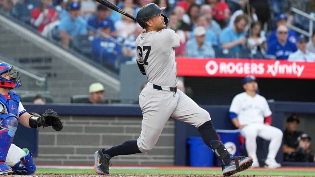 Jul 21, 2025; Toronto, Ontario, CAN; New York Yankees designated hitter Giancarlo Stanton (27) hits a home run against the Toronto Blue Jays during the fourth inning at Rogers Centre. 