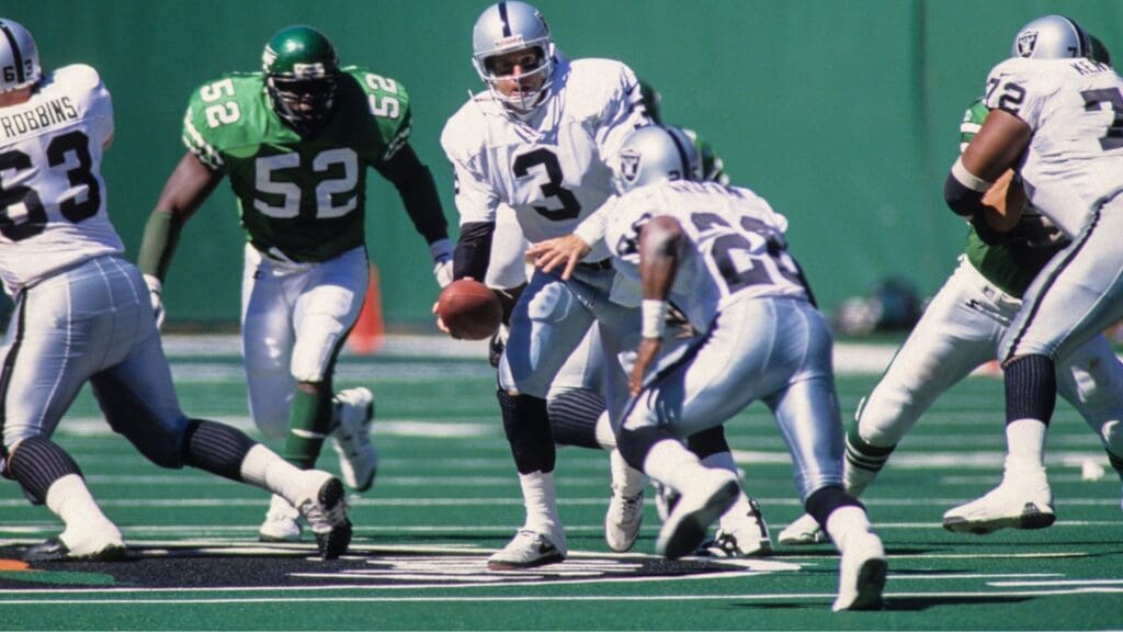 Sep 21, 1997; East Rutherford, NJ, USA; FILE PHOTO; Oakland Raiders quarterback Jeff George (3) hands the ball off to Napoleon Kaufman (26) against New York Jets linebacker Pepper Johnson (52) at Giants Stadium. 