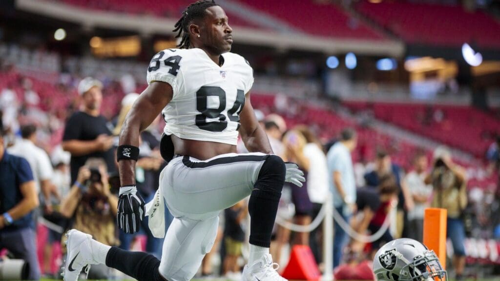 Aug 15, 2019; Glendale, AZ, USA; Oakland Raiders wide receiver Antonio Brown (84) stretches next to his helmet against the Arizona Cardinals during a preseason game at State Farm Stadium.