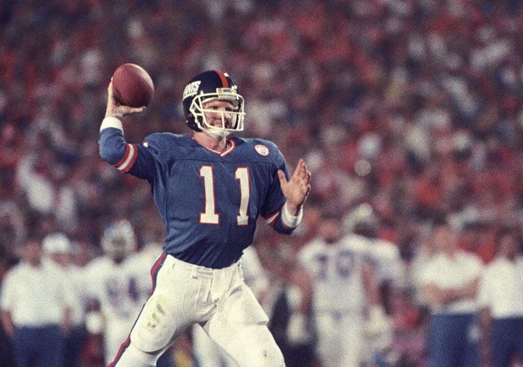 Jan 25, 1987; Pasadena, CA, USA; FILE PHOTO; New York Giants quarterback Phil Simms (11) looks to throw against the Denver Broncos during Super Bowl XXI at the Rose Bowl. The Giants defeated the Broncos 39-20. 