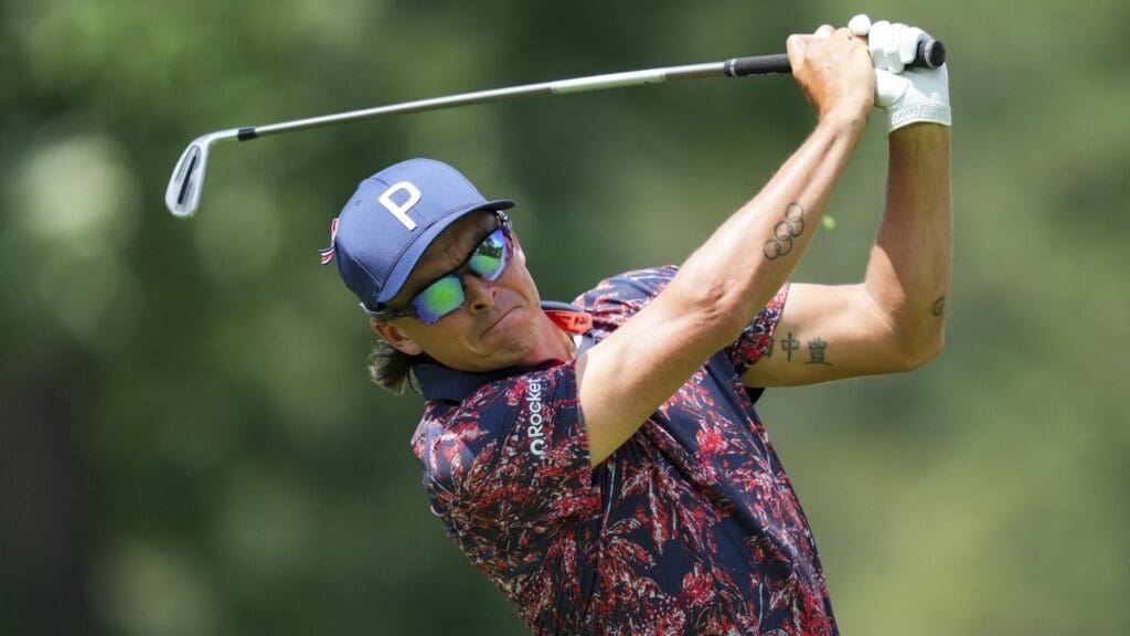 Jun 27, 2025; Detroit, Michigan, USA; Rickie Fowler plays his shot from the ninth tee during the second round of the Rocket Mortgage Classic golf tournament.