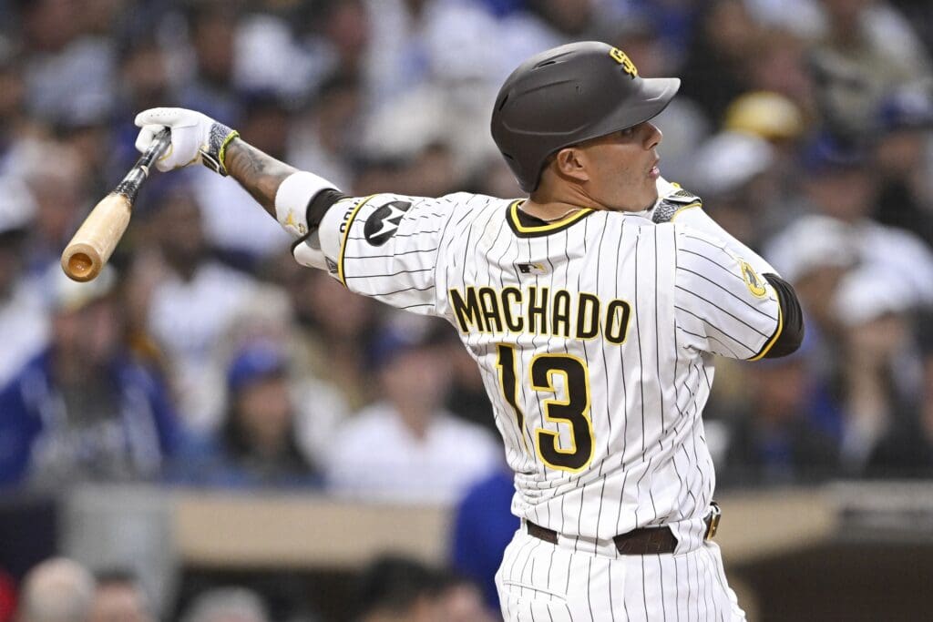 Jun 10, 2025; San Diego, California, USA; San Diego Padres third baseman Manny Machado (13) hits a RBI single during the third inning against the Los Angeles Dodgers at Petco Park.