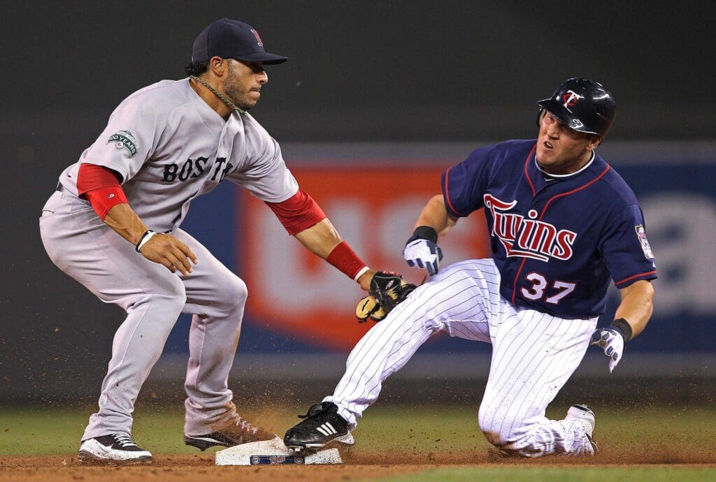 Apr 24, 2012; Minneapolis, MN, USA: Minnesota Twins pitch hitter Sean Burroughs (37) slides safely into second base before Boston Red Sox third baseman Mike Aviles (3) can tag him out during the ninth inning at Target Field. The Red Sox won 11-2.