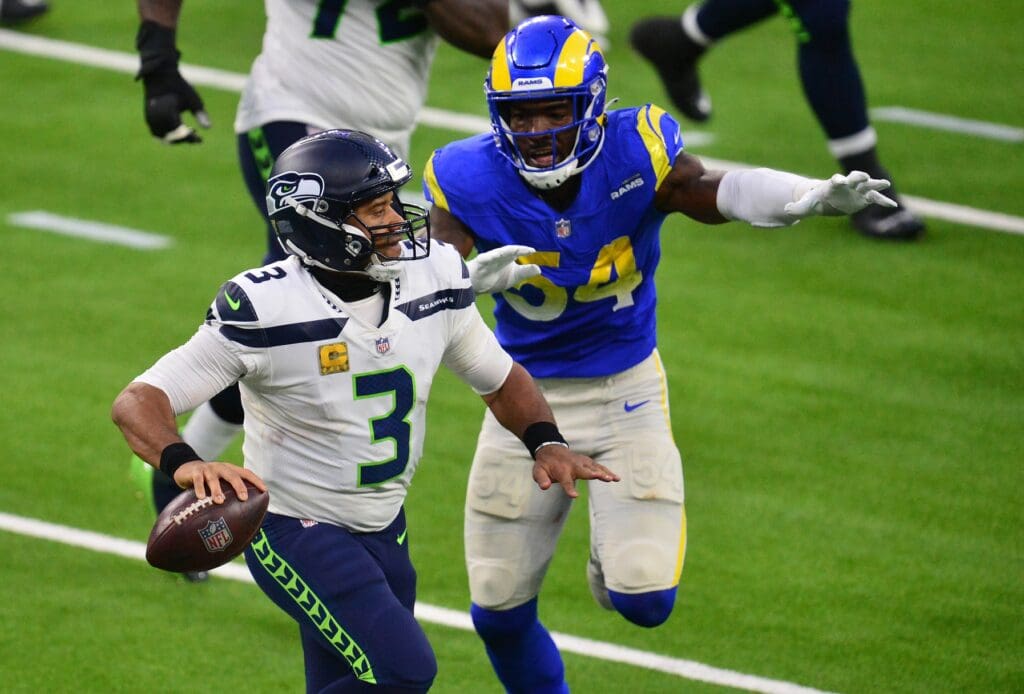 Nov 15, 2020; Inglewood, California, USA; Seattle Seahawks quarterback Russell Wilson (3) moves out to pass as Los Angeles Rams outside linebacker Leonard Floyd (54) moves in during the second half at SoFi Stadium.