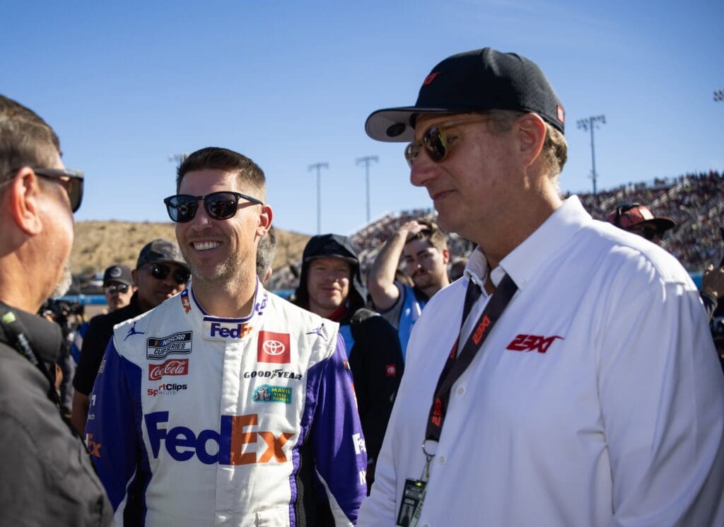 Nov 10, 2024; Avondale, Arizona, USA; NASCAR Cup Series driver Denny Hamlin (left) with 23XI Racing president Steve Lauletta during the NASCAR Cup Series Championship race at Phoenix Raceway. Mandatory Credit: Mark J. Rebilas-Imagn Images